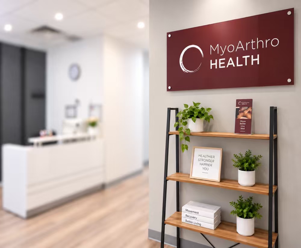 MyoArthro Health wall sign above a shelf with plants beside reception